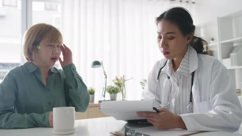 Young Asian female doctor is delivering great news talk results with girl patient hospital