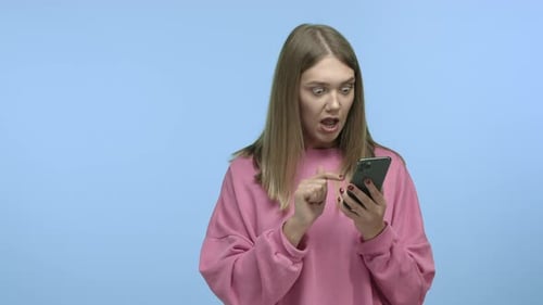 Slow Motion of Young Woman Using Smartphone Widen Eyes and Staring Surprised at Phone Screen Turn