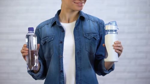 Woman Presents Two Bottles of Water