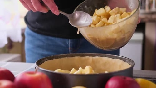 Diced Apples Being Added to Pie Pan