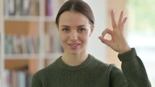 Young Woman Smiling Making OK Hand Gesture
