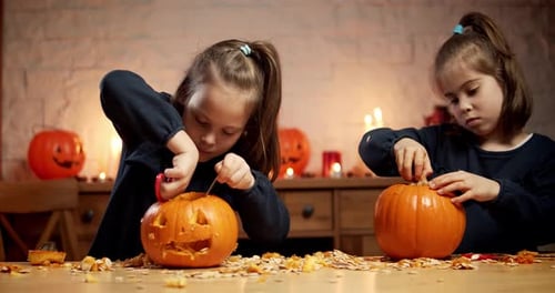 Two Girls Carving Pumpkins for Halloween