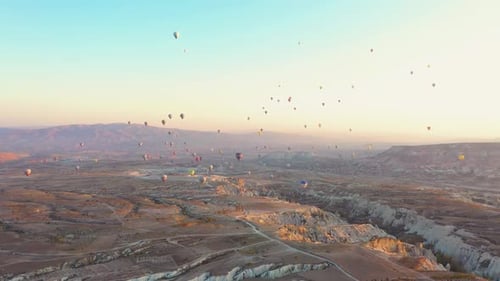 Hot Air Balloons Flying Over Rocky Landscape