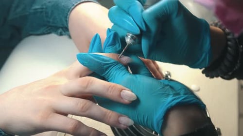 Manicure Master Doing Manicure - Cleans the Cuticle Using Device