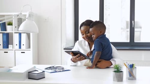 Doctor Showing Tablet Pc To Baby Patient at Clinic