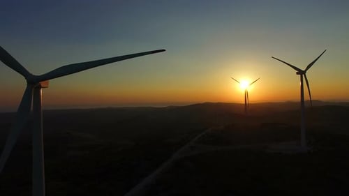 Close up aerial view of windmill blades at sunset