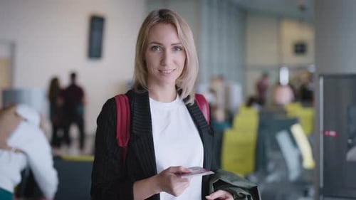 An Attractive Young Woman at the Airport is Waiting for Her Departure
