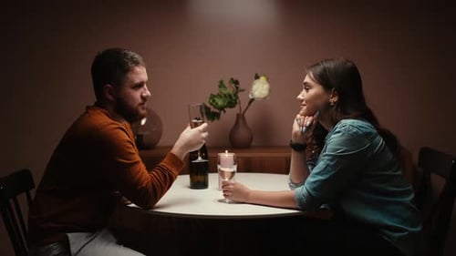Romantic Couple Toasting with Wine Over Candlelit Dinner