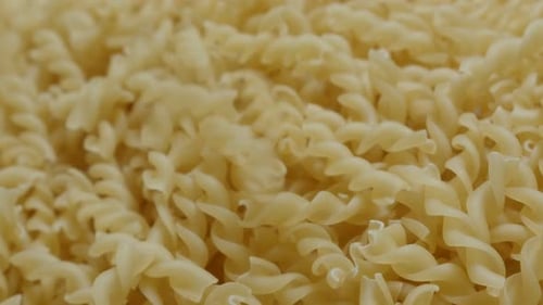 Corkscrew shaped pasta pile fall on table close-up 4K 2160p 30fps UltraHD footage - Falling on top