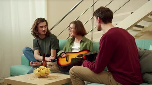 Friends Relaxing at Home with Guitar and Snacks