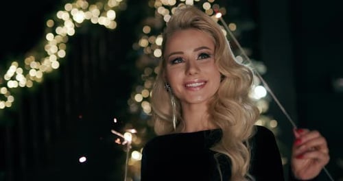 A Young Woman Admires the Sparklers in Her Hands. Slow Motion Video