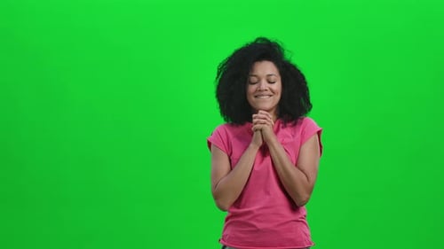 Woman Clasping Hands and Looking Upward on Green Screen
