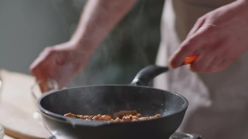 Man Flambeing Meat in Skillet