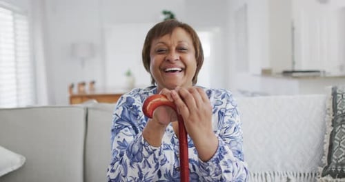 Smiling Woman Holding Walking Stick Inside