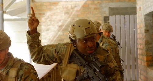 Front view of mixed-race military soldiers walking with rifles during military training 4k