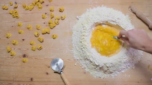 Crop woman preparing dough at table in kitchen