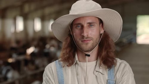 Man in Hat in Livestock Barn Close Up