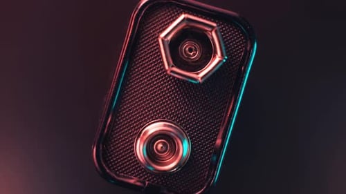 A 9Volt Battery Rotates and Shines in Beams of Light Against a Dark Background