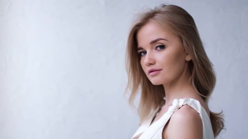 Close Up Portrait of Girl with Waving Blonde Hair Posing at Studio