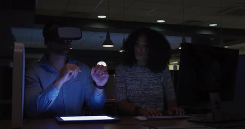 Young office executives working over digital tablet and using VR helmet in a modern office