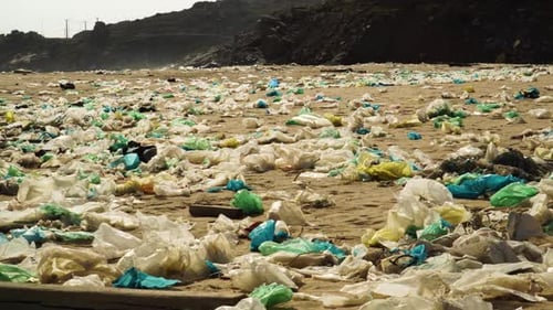 Waste covered sandy beach coastline of Vietnam, pan left view