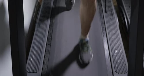 Adult male in sneakers walking on a treadmill