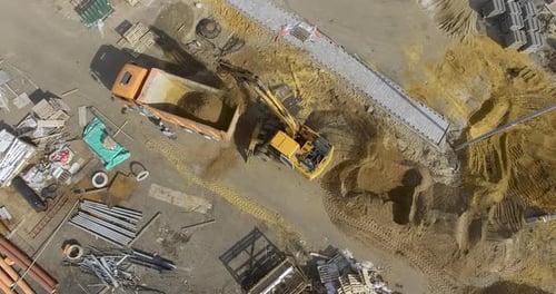 Excavator Loading Soil into a Truck, Aerial View