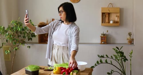 Mujer hace una lección en Vídeo sobre cocina, en el teléfono celular, en el teléfono inteligente
