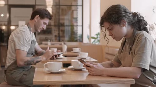 Restaurant Employees Using Smartphones by Tables