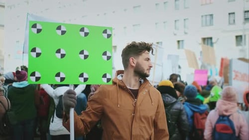 Man Holding Chroma Key Sign in Crowd Protesting