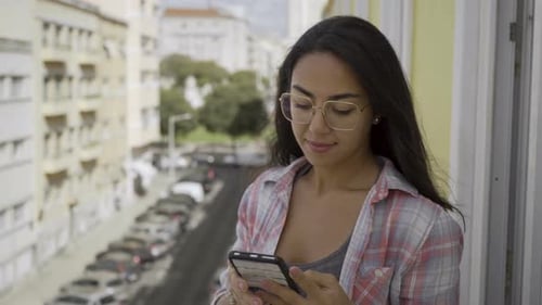 Woman Smiling Using Cellphone on Balcony