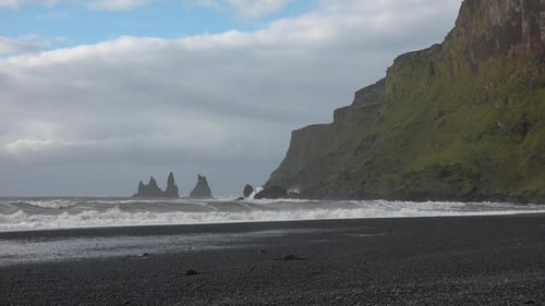 Beautiful nature in Iceland. Huge waves crashing and splashing on a Black Beach. Basalt rocks.