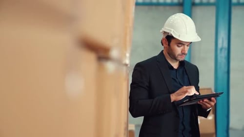 Factory Manager Using Tablet Computer in Warehouse or Factory