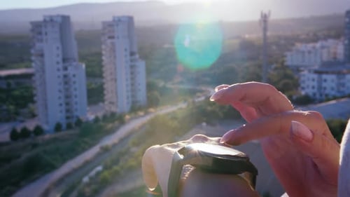Woman Uses Smartwatch in Urban Setting