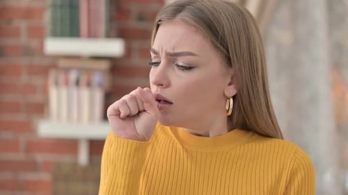 Blond Woman Coughing, Feeling Sick Indoors