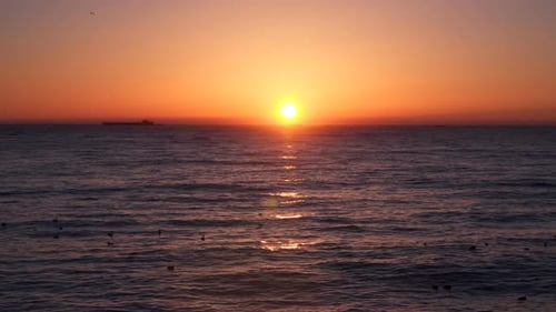 Sunrise Over the Sea We See a Cargo Ship On the Horizon