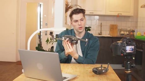 Netter kaukasischer Blogger präsentiert der Kamera einen Quadrocopter, während er ein Video für sein YouTube aufnimmt