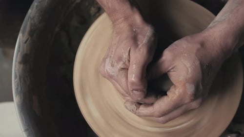 Potter façonne le produit en argile avec des outils de poterie sur le tour de potier Vue de dessus Cinématographique tonique