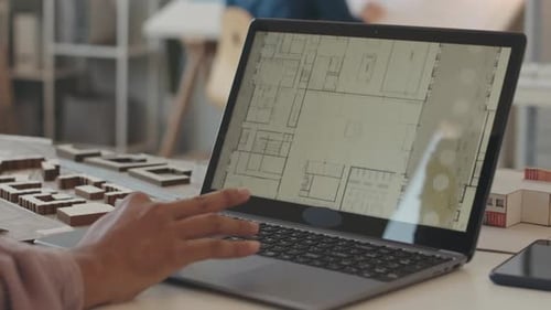 Architect Creating House Plan on Laptop