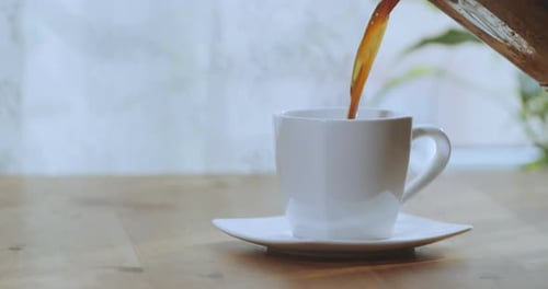 Steaming Coffee Being Poured into a White Mug