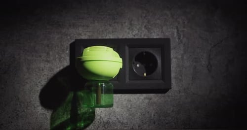 Green Air Freshener plugged into Gray Wall Outlet