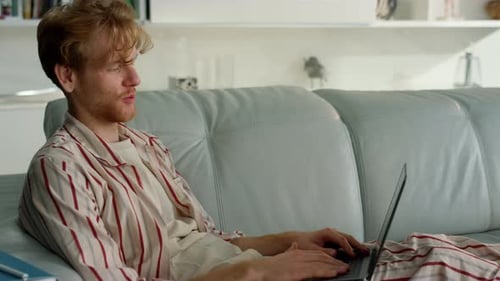 Young Man Video Calling at Home on Laptop