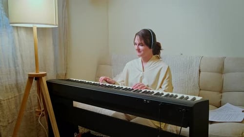 Woman Plays Electronic Piano with Headphones On