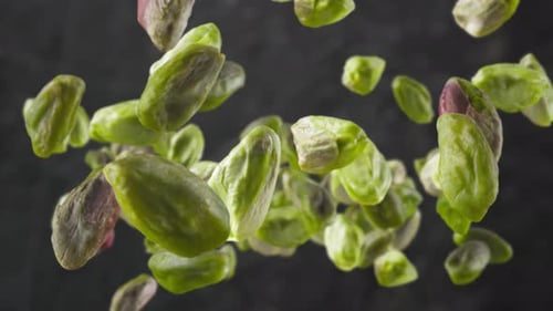 Pistachios Falling in Slow Motion on Dark Background