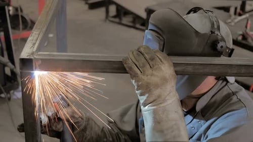 Trabajador en taller. Proceso de soldadura. Un soldador con casco haciendo su trabajo.
