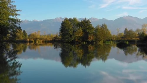 Quiet autumn fishing landscape. Lake at the edge of the mountains with forest