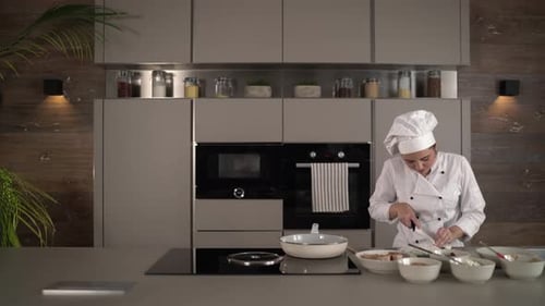 Woman Chef Chopping Ingredients in Modern Kitchen
