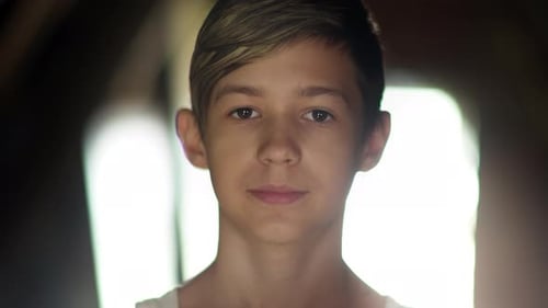 Portrait of a Happy Boy Looking at the Camera and Smiling