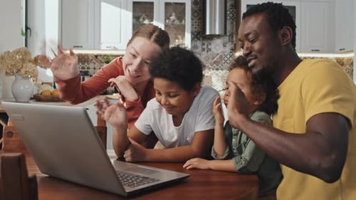 Happy Family Video Calling on Laptop in Kitchen