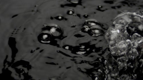 Wasser sprudelt schwarze Seite